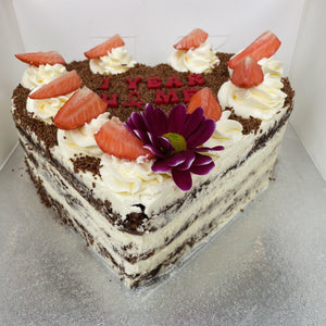 Side view Image of the Yasmin Bakery & Catering heart shaped Black Forest cake Several layers of chocolate sponge cake sandwiched with whipped cream and cherries